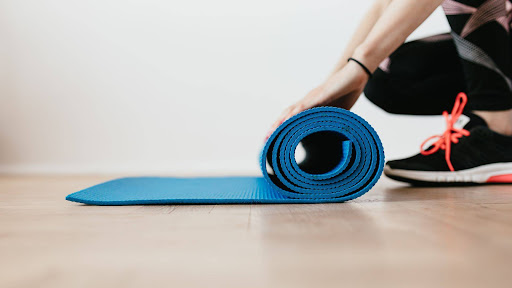 A person rolls a yoga mat.